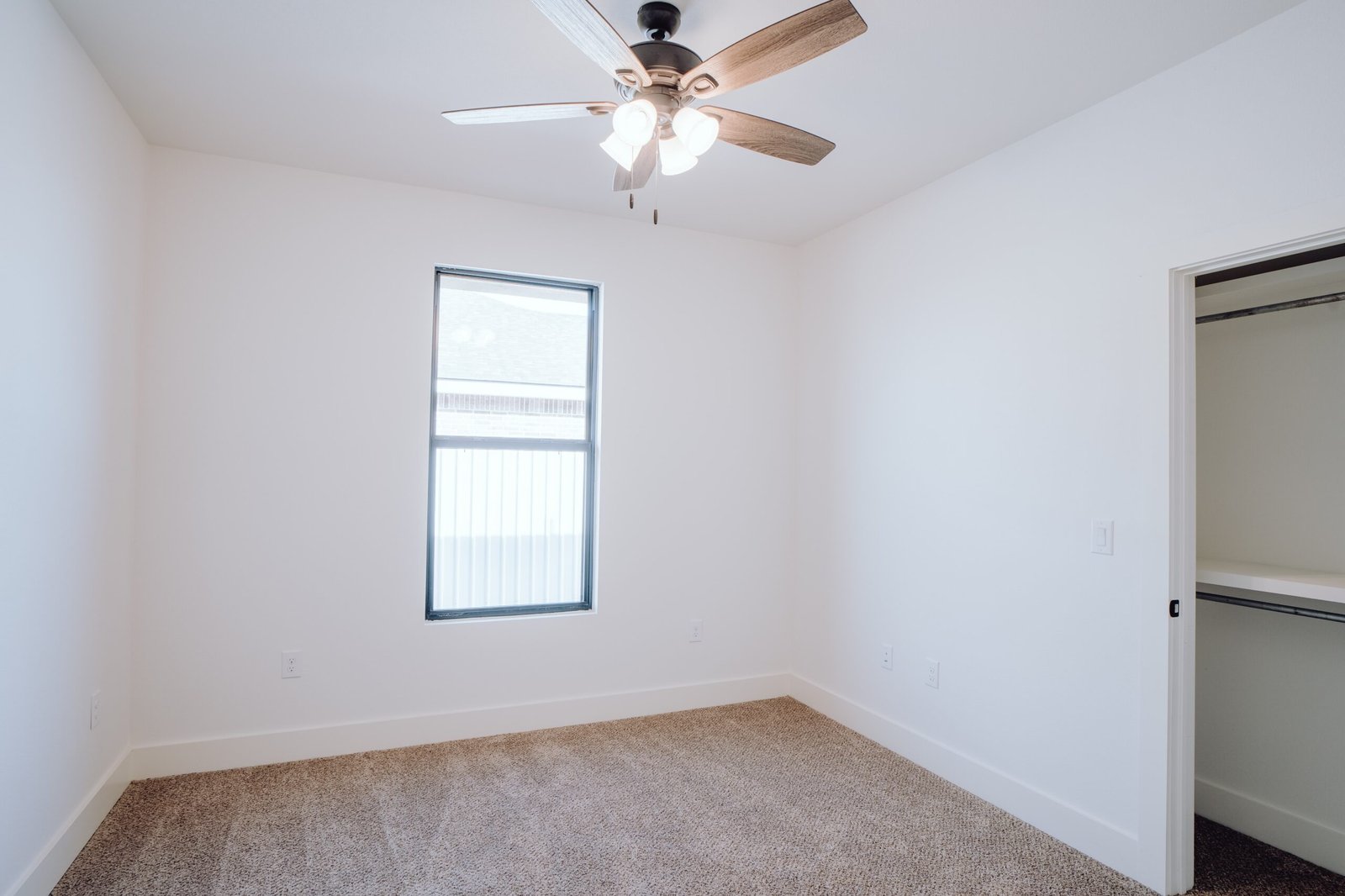 Empty room with a ceiling fan and window