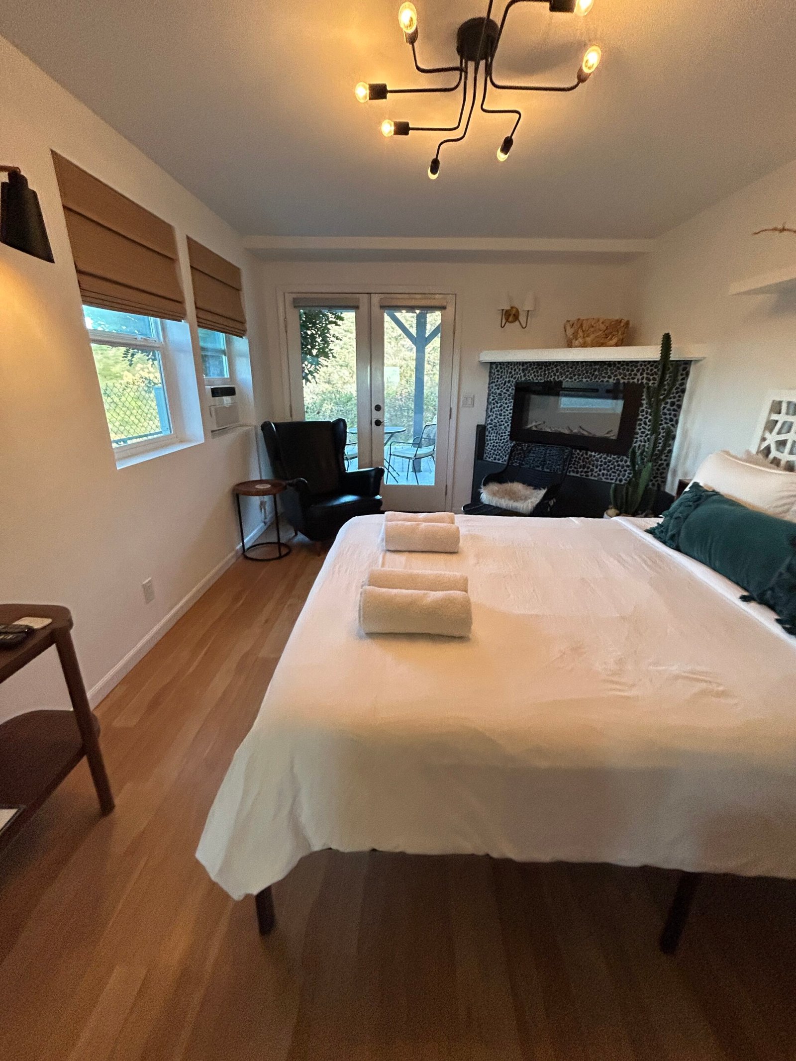 Bedroom reset with a freshly made bed and folded towels after a recurring house cleaning visit
