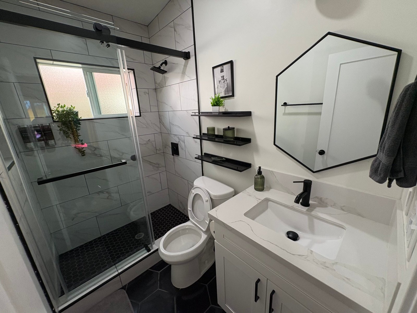 Bathroom with glass shower, toilet, and vanity cleaned and sparkling during a Suddenly Clean recurring cleaning visit