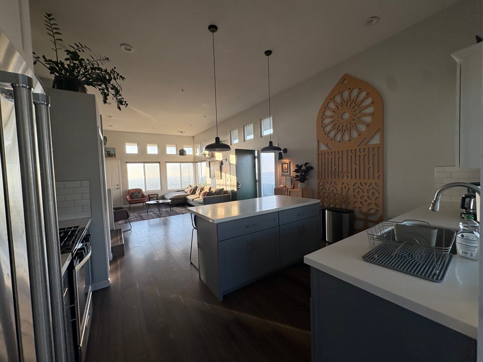 Open-concept kitchen and living area with wood floors vacuumed and surfaces wiped down during a recurring house cleaning visit