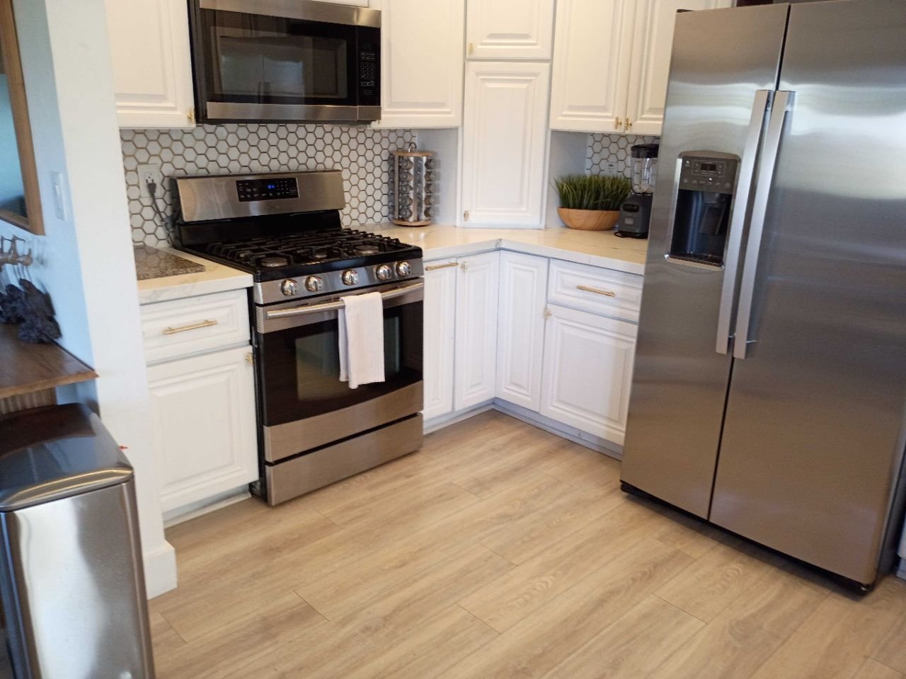 Clean kitchen with white cabinets, oven and refrigerator