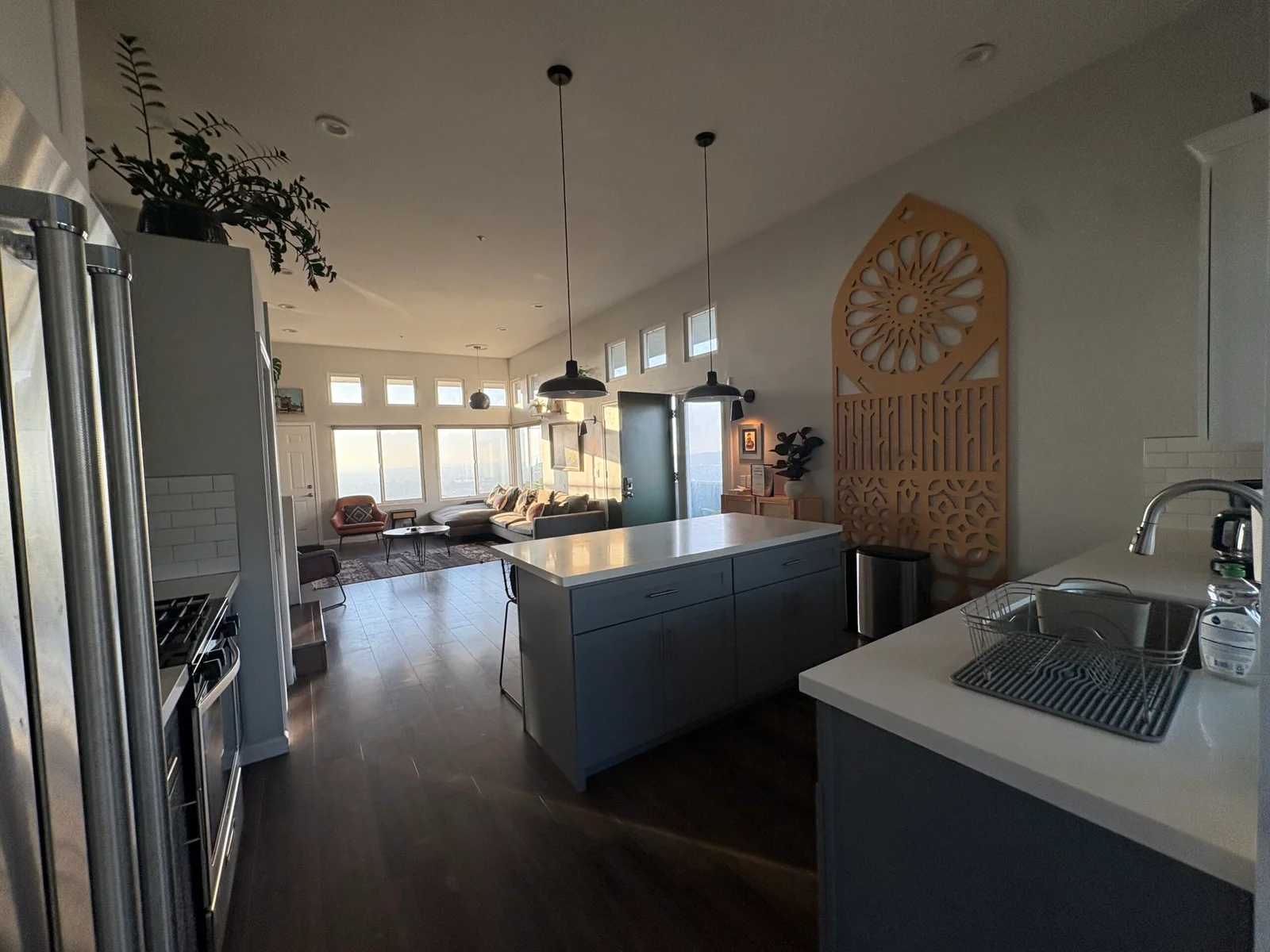 Open-concept kitchen and living area with wood floors vacuumed and surfaces wiped down during a recurring house cleaning visit