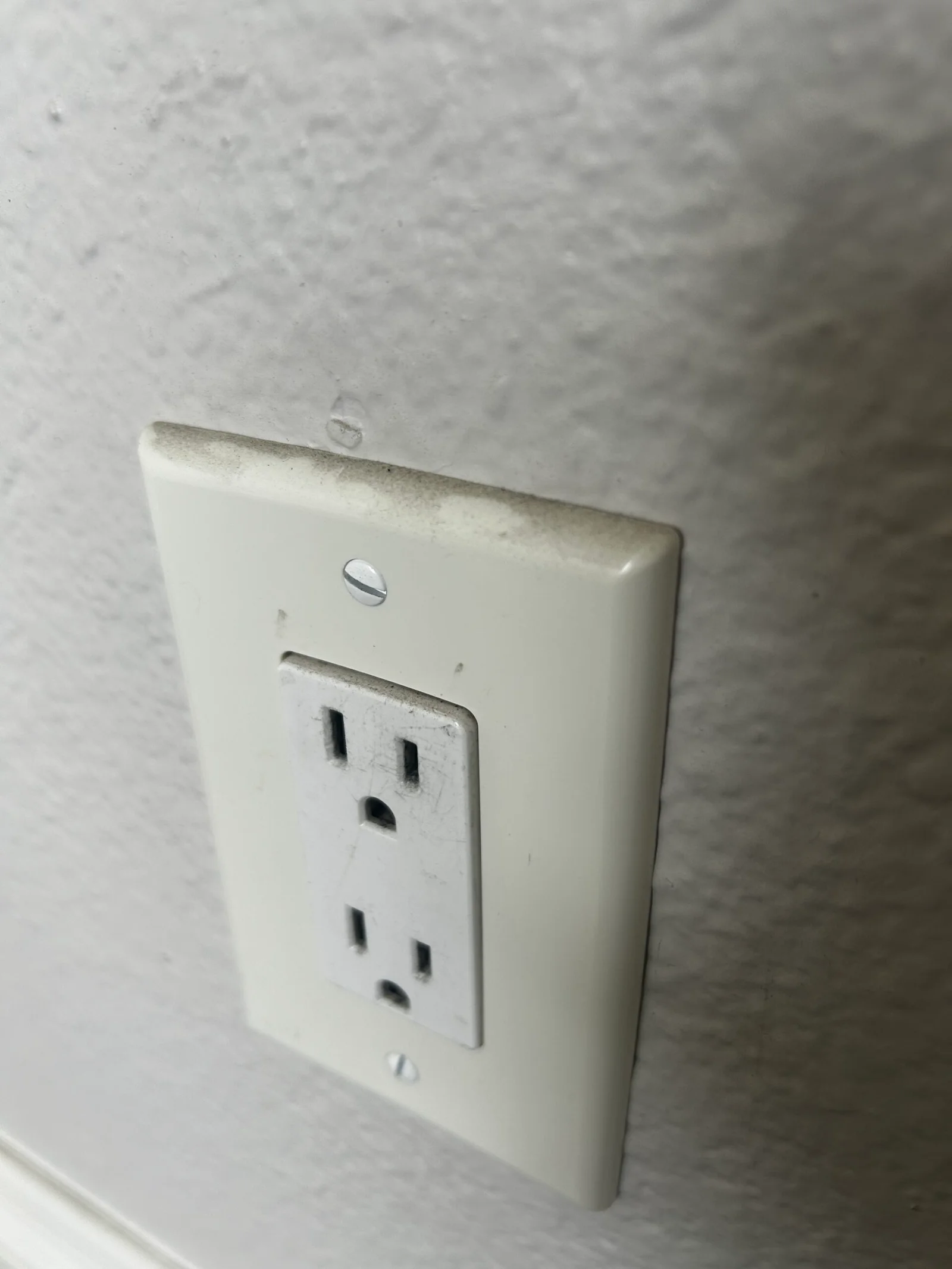 Close-up of a clean, dust-free electrical outlet and wall surface