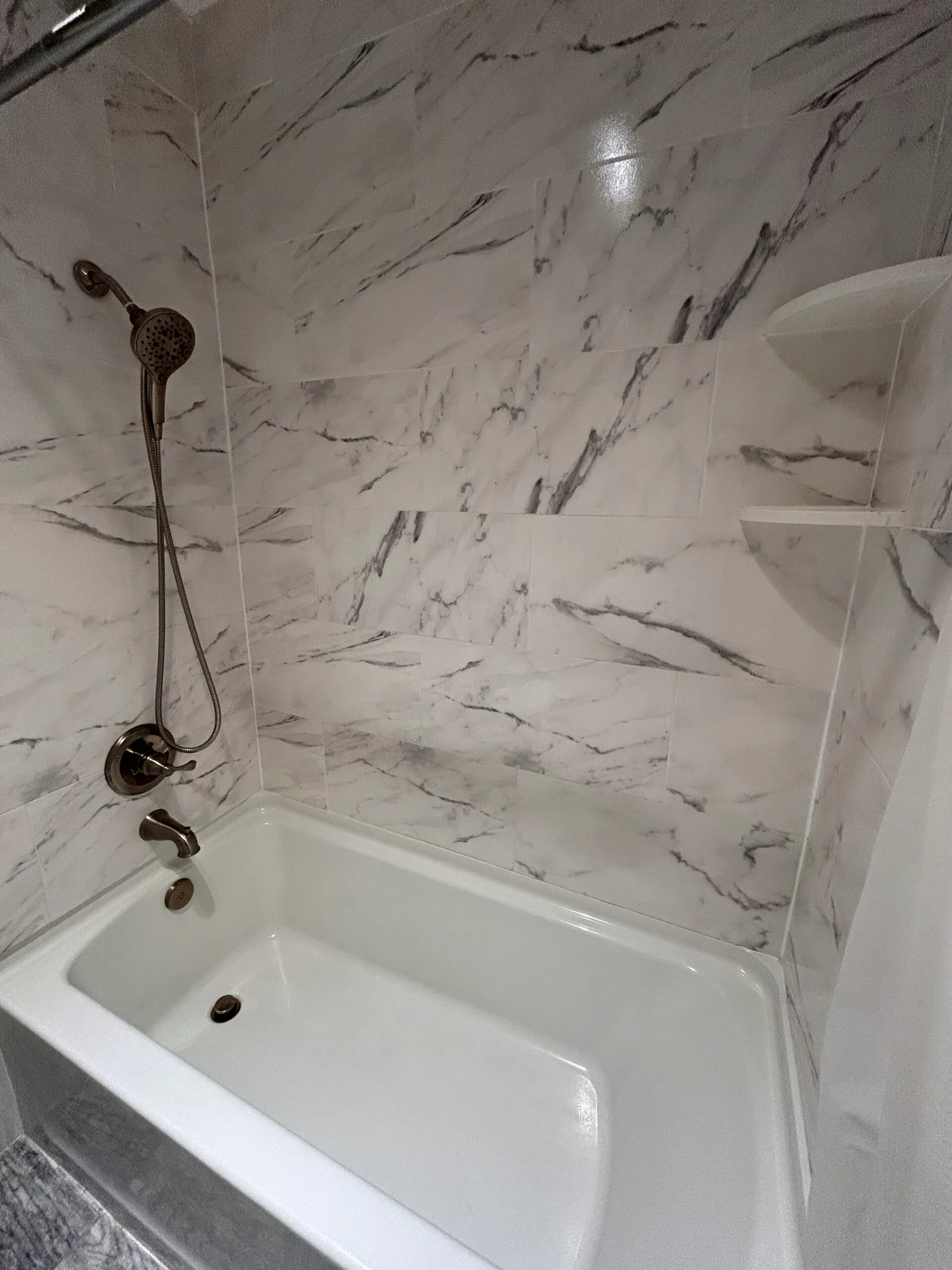 Spotless marble shower and tub after a Suddenly Clean visit