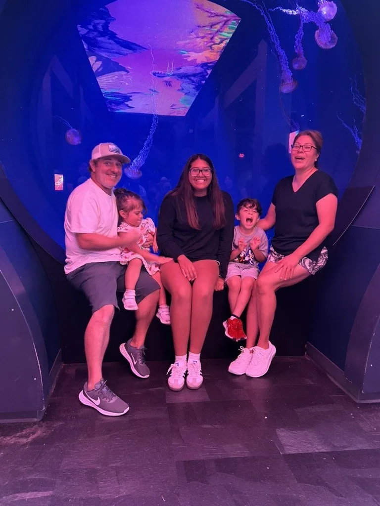 The family of five together during a visit to an aquarium jellyfish exhibit