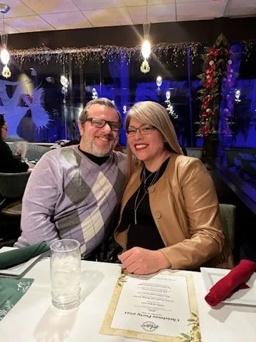 Paul and Lina smiling together at a holiday dinner out