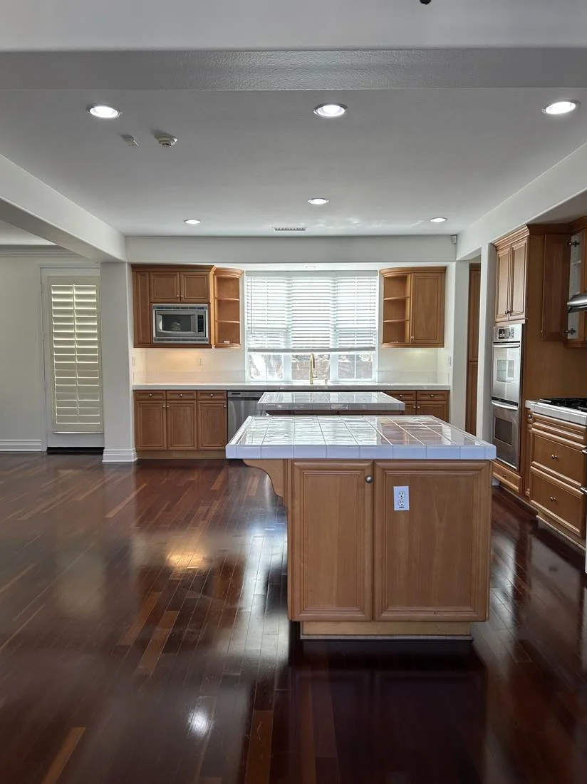 Vacant, move-out clean kitchen with wood floors in an East County San Diego home