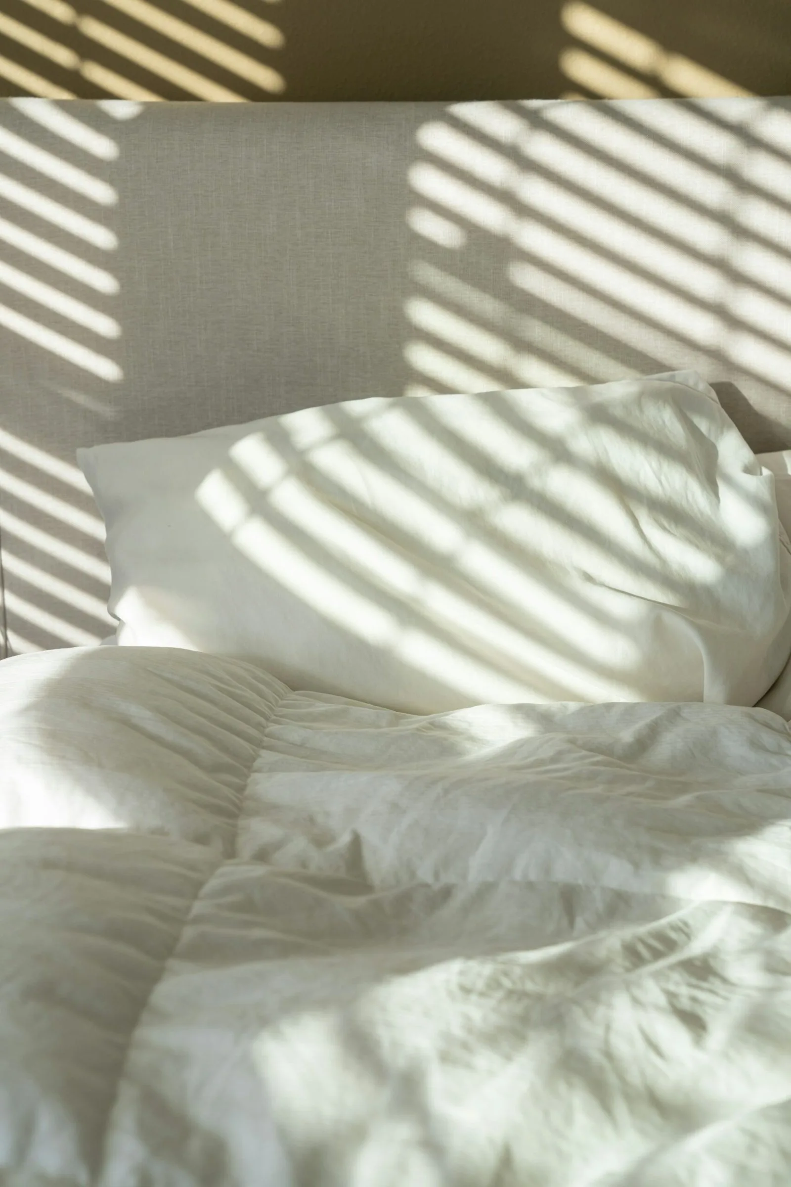 Freshly made bed with clean linens after a professional house cleaning