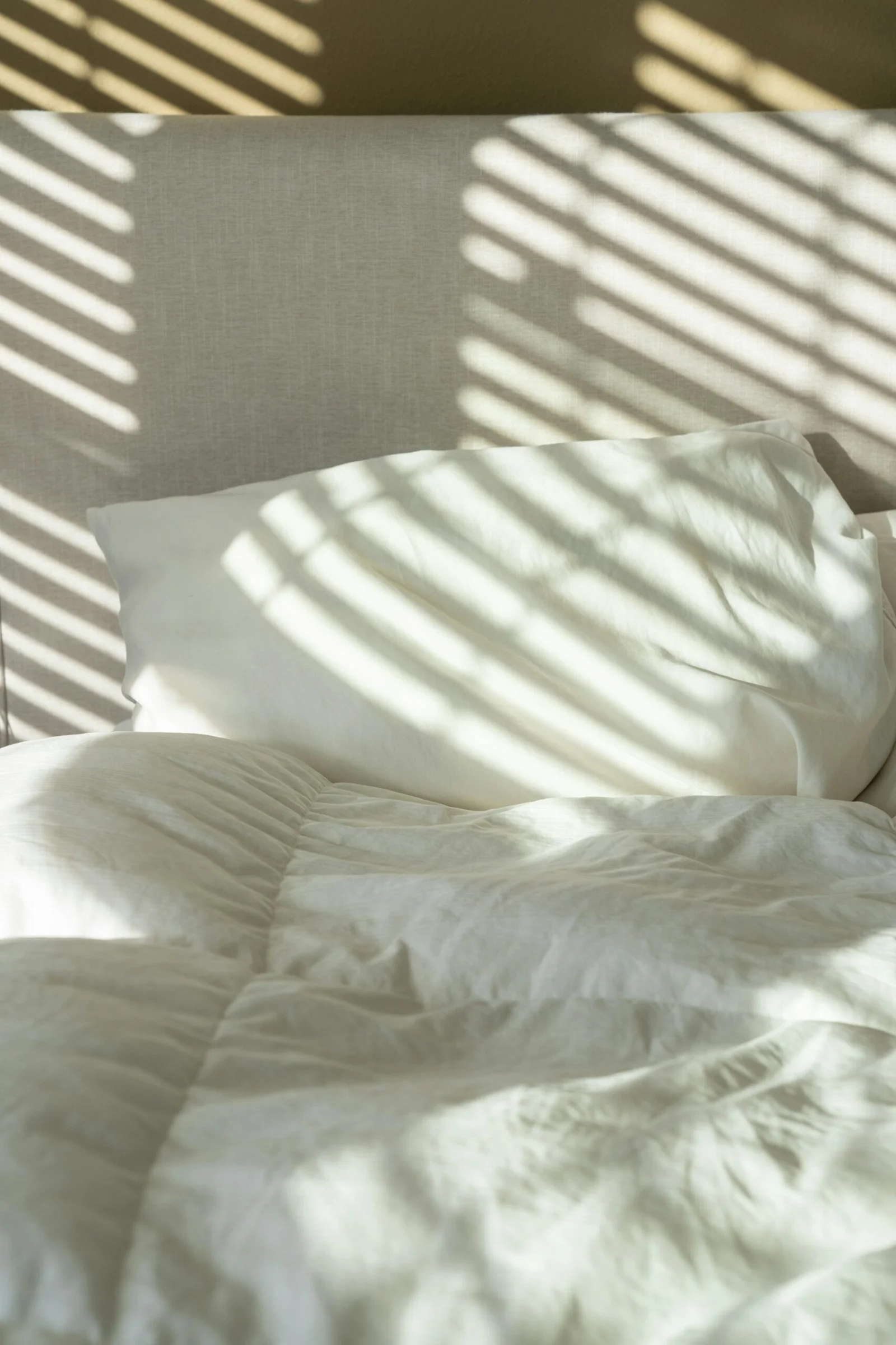 Freshly made bed with clean linens after a professional house cleaning