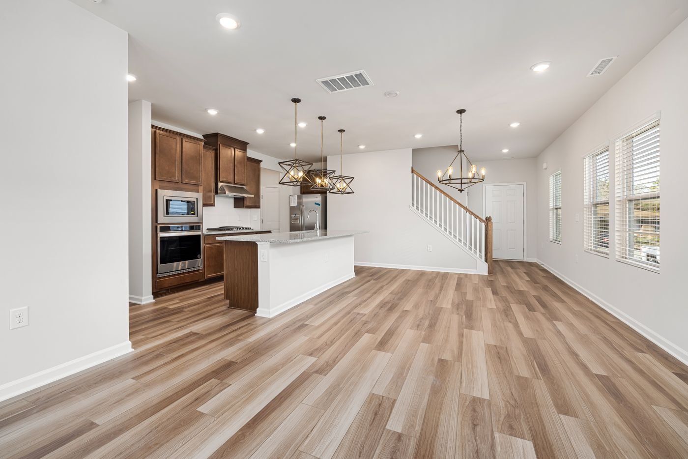 Bright open kitchen and living area with wide plank floors