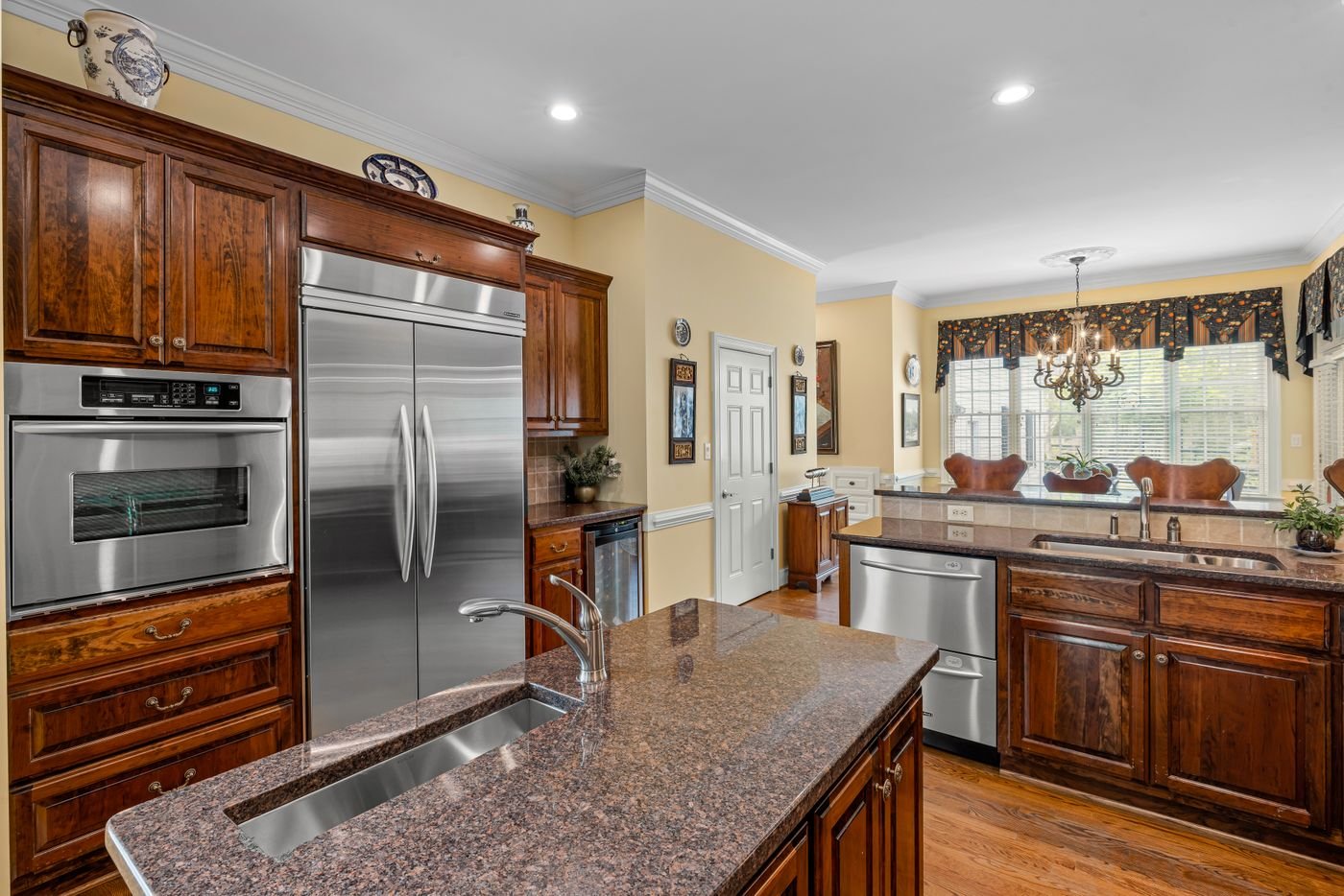 Wood cabinet kitchen with double wall ovens and a stainless refrigerator